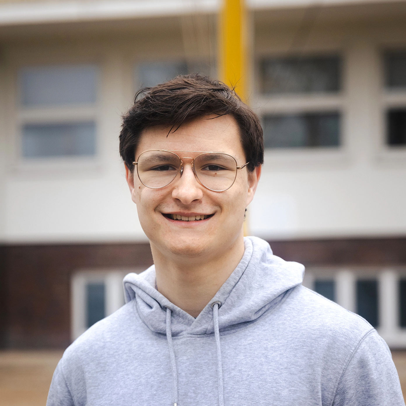 Profile Image, front shot of Jonas Happ with the brand university building in the background
